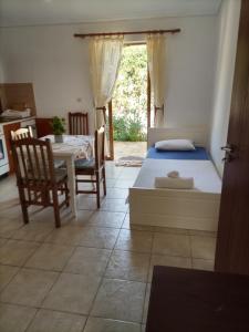 a bedroom with a bed and a table and chairs at Baci Apartments in Ksamil