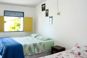 une chambre avec deux lits et une fenêtre dans l'établissement Casa na ilha da Crôa, à Barra de Santo Antônio 26 autres photos