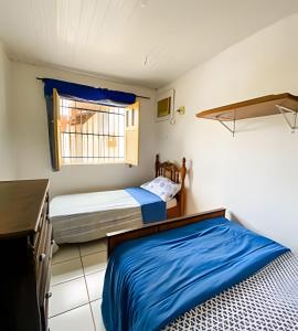 une chambre avec deux lits et une fenêtre dans l'établissement Casa na ilha da Crôa, à Barra de Santo Antônio