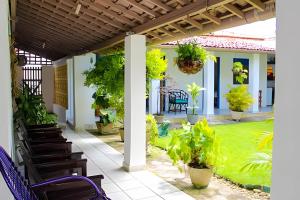 un patio avec des chaises et des plantes sur une maison dans l'établissement Casa na ilha da Crôa, à Barra de Santo Antônio