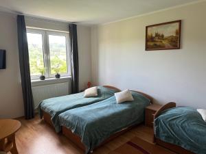a bedroom with two twin beds and a window at Holica in Krynica Zdrój