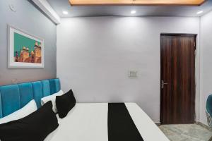 a bedroom with a bed and a wooden door at Hotel O The smart haven in Ghaziabad +40 photos