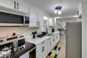 une cuisine avec des armoires blanches et un réfrigérateur en acier inoxydable dans l'établissement Walkable Greenville Home Near Dtwn, à Greenville