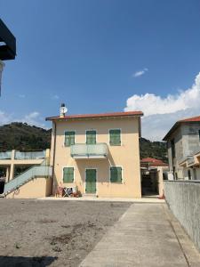 a large building with green shutters on it at Casa Cristina in Ventimiglia