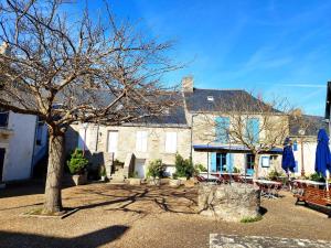 een groot gebouw met een boom en tafels en stoelen bij Ô Coeur d'Eden ,2 mobilhomes l'Ôriginal et le BÔ'Aime in Piriac-sur-Mer
