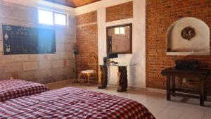 a bedroom with a bed and a table and a brick wall at Casa Müi in Tequisquiapan