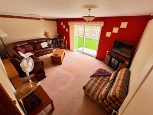 a living room with a couch and a tv at Devon Bungalow in Holsworthy