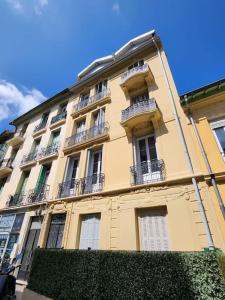 un grande edificio giallo con balconi sul lato di Nice Fac St Jean D'Angely a Nizza