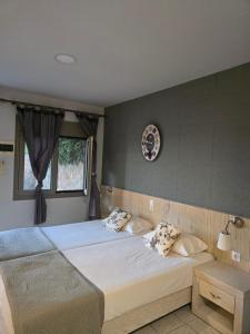 a bedroom with two beds and a clock on the wall at Attalos Apartments in Agia Pelagia +50 photos