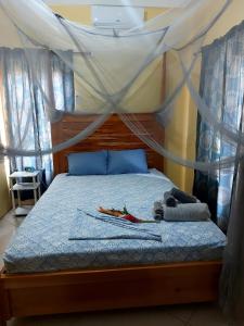 a bedroom with a canopy bed with a stuffed animal on it at Desired View in Choiseul