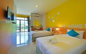 a hotel room with two beds and a tv at Kiss Hometel in Ao Nang Beach