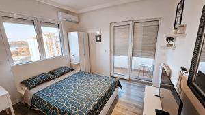 a bedroom with a bed and a large window at Dorcol deluxe apartment in Belgrade