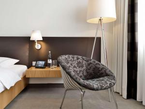 una camera con sedia, letto e lampada di Dorint Hotel Bremen a Brema