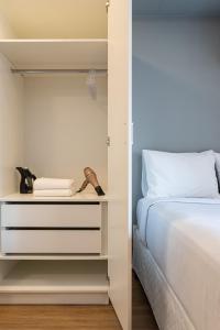 a bedroom with a bed and a closet with a dresser at Aurora Paulistana by Viva - Prédio completo a passos do Metrô República in Sao Paulo
