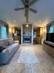 Una sala de estar con un sofá y un televisor. en 56 Main Park Caravan Hire Lillardsedge Holiday Park Jedburgh, en Jedburgh