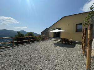 a patio with a table and an umbrella at Tuvo Houses in Levanto +16 photos