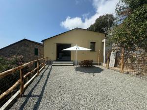 a patio with an umbrella and a building at Tuvo Houses in Levanto