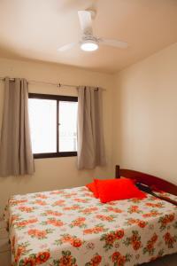 MuquiçabaにあるApto a 190m do mar da Praia do Morro -Guarapari ESのベッドルーム1室(赤い枕と窓付)