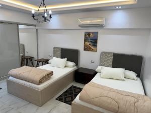 a room with two beds and a dining room at شقة فندقية على النيل in Mansoura