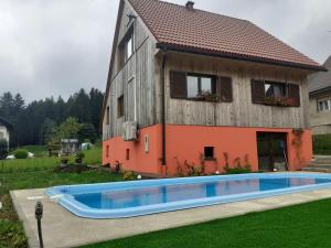 a house with a swimming pool in front of it at Seoska rapsodija in Tršće