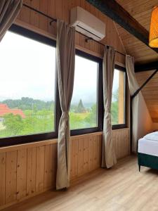 a bedroom with windows and a bed in a room at Seoska rapsodija in Tršće +28 photos