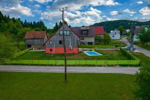 a house on a hill with a yard and a pool at Seoska rapsodija in Tršće