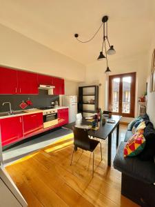a kitchen with red cabinets and a table in a living room at Harry Potter House - 10 min to Centrale in Milan