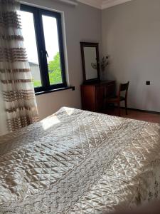 a bedroom with a large bed and a window at Jrvezh House in Yerevan