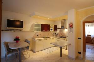 a kitchen with white cabinets and a table and chairs at Casa Gabriella in Fiera di Primiero
