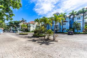 a cobblestone street with palm trees and houses at Victorian Condominium, Cabarete! in Cabarete