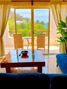 a living room with a table and a view of the ocean at Villa DALIJÚ in Santa Cruz Huatulco