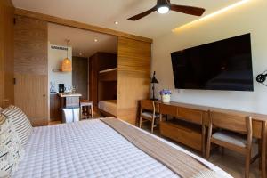 a bedroom with a bed and a flat screen tv at Hermoso Estudio frente al mar, Zantamar 304 in Cruz de Huanacaxtle