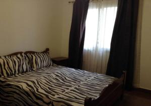 a zebra print bed with a window in a bedroom at La Belle maison in Dakar
