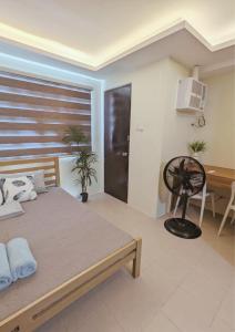 Lapu Lapu CityにあるKing Bed, Big Kitchen, Fast WiFi, Near Airportのベッドと机とテーブルのある寝室