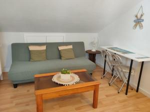 a living room with a green couch and a table at Habitación Anjana in Renedo de Piélagos +14 photos