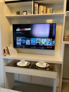 a tv on a table with two cups and plates at Overnight @ Shakhbot's in Manila +18 photos