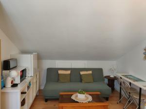 a living room with a green couch and a table at Habitación Anjana in Renedo de Piélagos