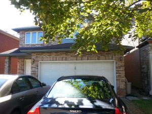 um carro estacionado em frente a uma casa com garagem em Maria's Homestay em Thornhill