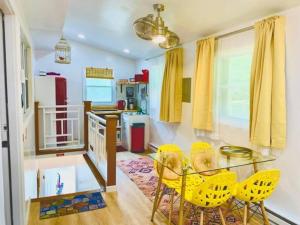 a dining room with a glass table and yellow chairs at The Great Heron Nest, Catskill sleeps 4, AC, #6 in Shandaken