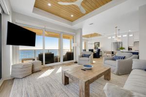 Una sala de estar con un televisor, un sofá y una mesa. en Beachy Keen - High Pointe E41, en Inlet Beach