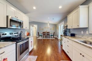 a kitchen with white cabinets and a wooden floor at Blueridge Brew View in Fairview