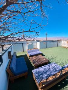 3 colchones y sillas en el techo de una casa en Rey Lagarto Hostel, en San Pedro de Atacama