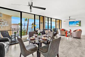 una sala de estar con una mesa y sillas en Milowai 401, en Wailuku
