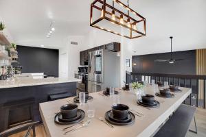 a kitchen with a long table with plates and utensils at Lux Fun Zone Home - Sleeps 16 in Mesa