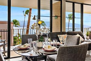 Un comedor con una mesa y un sofá. en Milowai 401, en Wailuku
