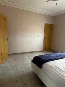 a bedroom with a bed in a room with a door at Maison Wartas in Berkane