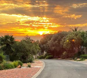 an empty road with a sunset in the background at Bult-Op1 in Bloemfontein