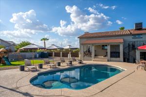 a swimming pool with chairs and a house at Your Unique Desert Compound - Amenities Galore in Peoria