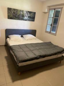 - un lit dans une chambre avec une tête de lit bleue dans l'établissement L escapade nature, à Saint-Brès 7 autres photos