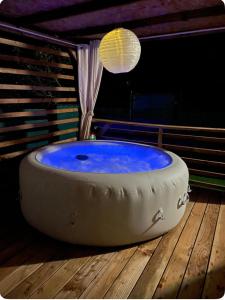 une grande baignoire assise sur une terrasse en bois dans l'établissement L escapade nature, à Saint-Brès